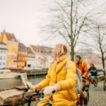 Photo of female travel guide and her group on the bicycles through the town